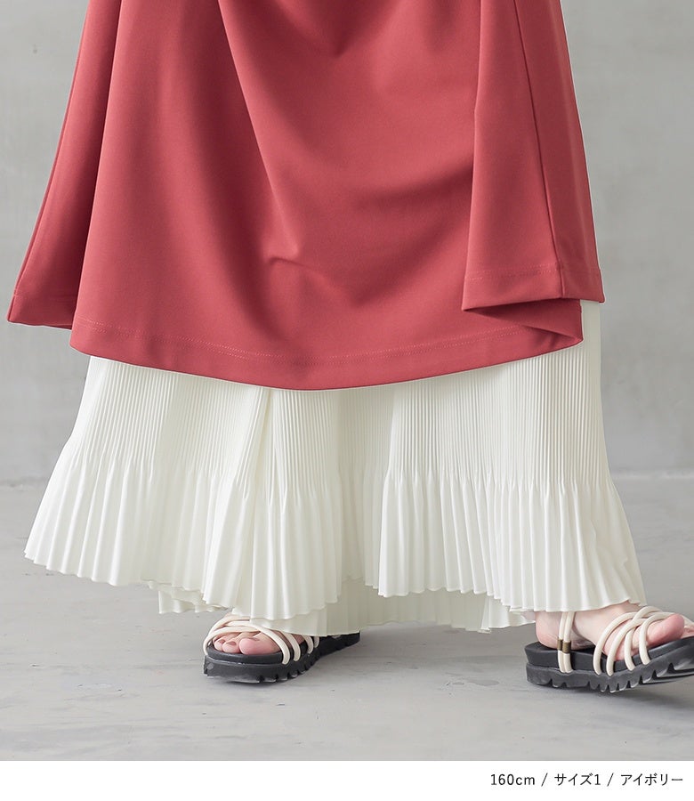 アイボリーのペチワイドパンツ。ワンピースの裾から覗く繊細なランダムプリーツと足元のサンダルが調和し、重たくなりがちなロング丈コーディネートに爽やかな抜け感を与えます。
