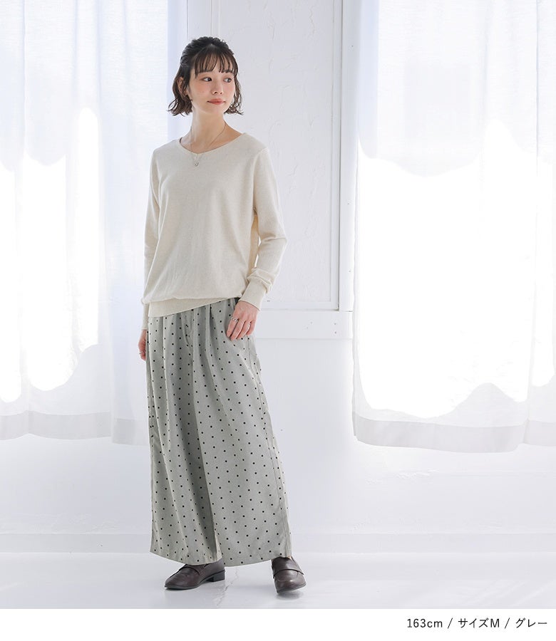 グレーのドット柄ワイドパンツにアイボリーのニットを合わせた優しげな着こなし。小粒のドット柄がシンプルなトップスにさりげないニュアンスと女性らしさをプラスします。