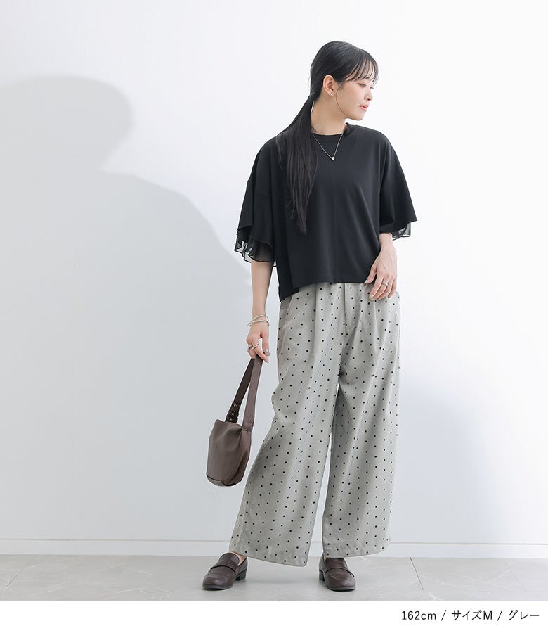 グレーのドット柄ワイドパンツに黒のフレアスリーブカットソーをあわせたきれいめスタイル。全体をモノトーン調で揃えることで、ドット柄の愛らしさを引き締め大人っぽく魅せます。