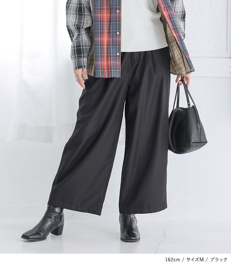 ブラックのワイドパンツにチェック柄シャツを羽織ったモードカジュアルスタイル。広がりすぎないストレートワイドラインが、カジュアルなレイヤードコーデに大人上品な落ち着きを与えます。