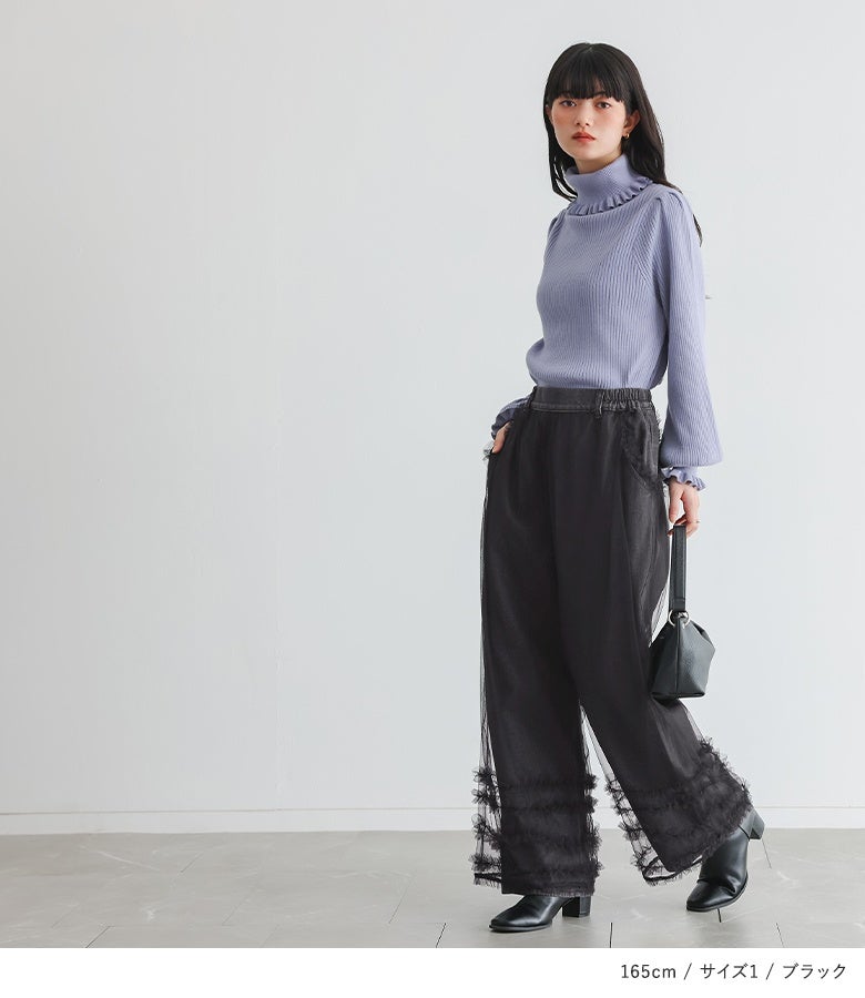 ブラックのチュール重ねティアードフリルデニムパンツ。パープルのニットをインした着こなしで、ウエスト位置が高く見え、ワイドシルエットながらすっきりとした脚長効果を発揮します。