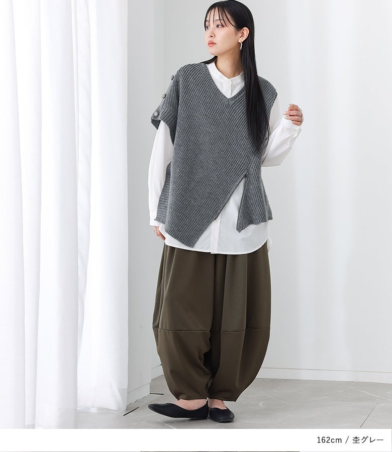 杢グレーのアシンメトリーニットベストにカーキのパンツをあわせた洗練スタイル。ゆとりのある身幅とアシメヘムが、体型をカバーしながら動きのある優雅なシルエットを演出します。
