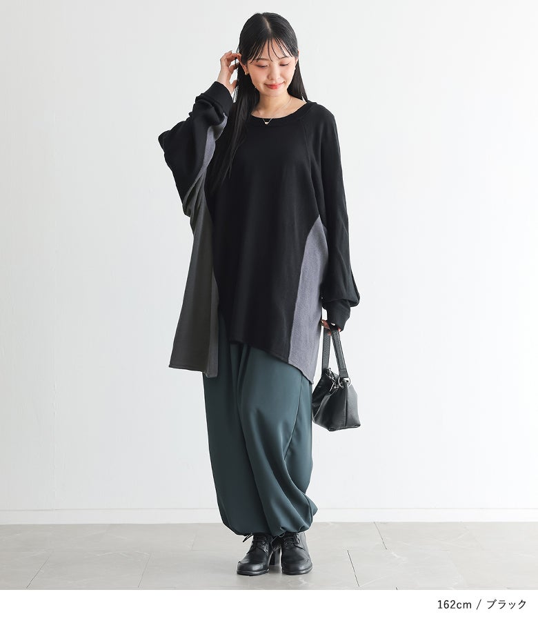 ブラック地のラグランスリーブニットに、ボリュームのあるワイドパンツとレザーバッグを合わせた大人の着こなし。斜めの配色切り替えが引き締め効果を叶え、秋の旅行や休日のお出かけに映えます。