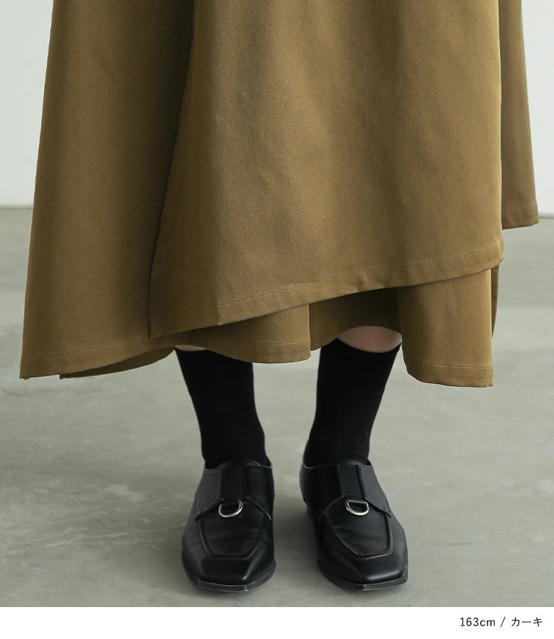 カーキの変形ラップパンツの美しい裾レイヤードディテール。程よい厚みの上質な布帛生地と斜めに重なるレイヤードラインが、歩くたびにしなやかな揺れ感を生み出し足元をおしゃれに彩ります。