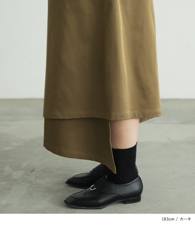 カーキの変形ラップパンツのアシンメトリーなヘムライン。前後左右で長さや重なりが異なる変形シルエットが立体的な陰影を作り出し、シンプルになりがちなスタイリングの主役になるデザインパンツです。