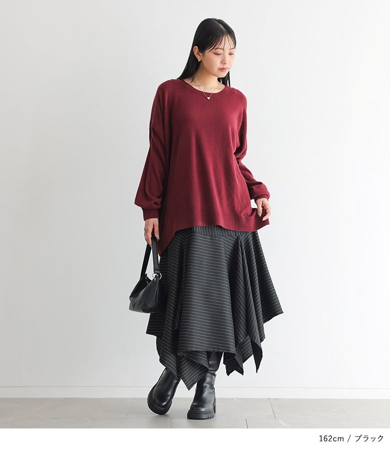 ブラックのストライプ柄アシメフレアスカート。深みのあるボルドーのゆったりニットに黒のロングブーツを合わせた、シックで華やかな秋冬のモードスタイルです。