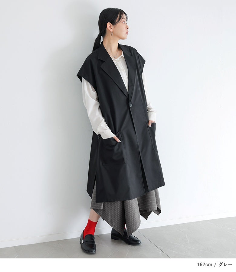 グレーのストライプ柄アシメフレアスカート。白シャツに黒のロングジレベストをレイヤードしたマニッシュな装いに、立体的なフレアラインが上品な華やかさをプラスします。