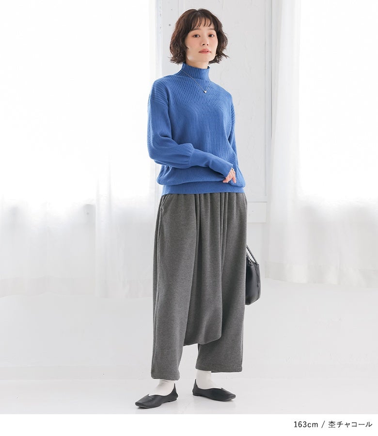 杢チャコールの裏シャギーサルエルパンツ。落ち着いた色合いとあたたかな穿き心地で、鮮やかなハイネックニットと合わせた大人のシックな休日スタイルを魅せます。
