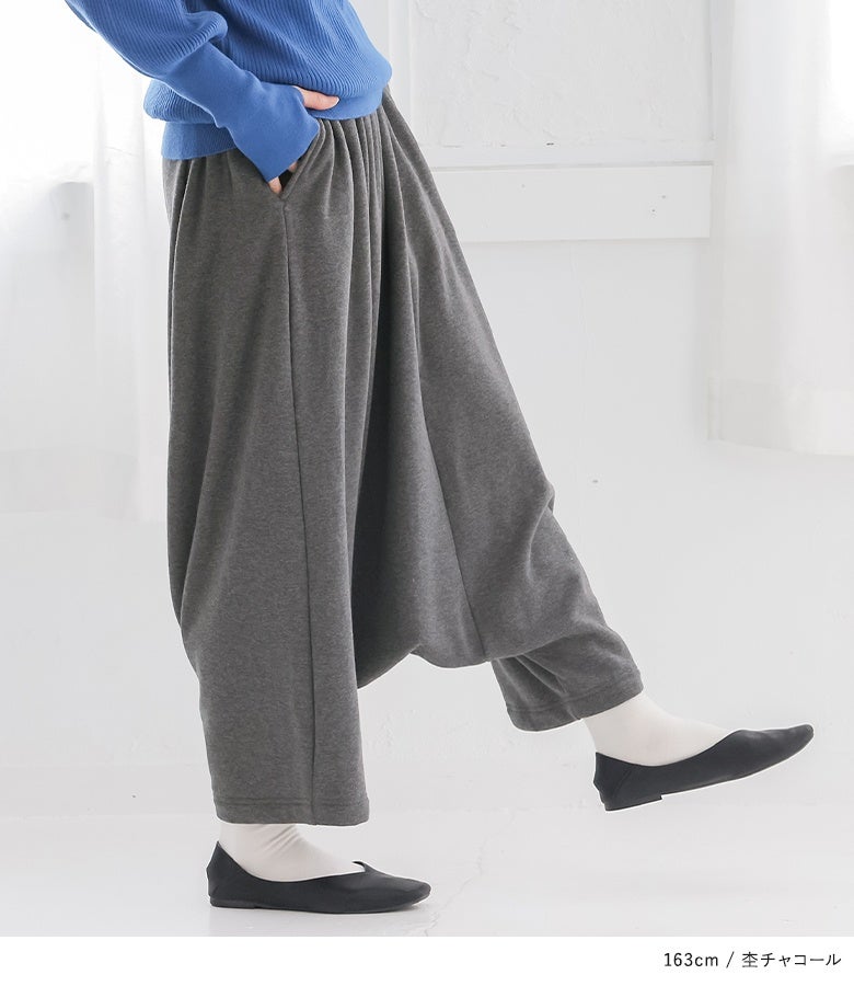 杢チャコールの裏シャギーサルエルパンツ。股上を深く取った立体的なドレープラインが、歩くたびにこなれたニュアンスを生み出し、モード感溢れる装いを叶えます。