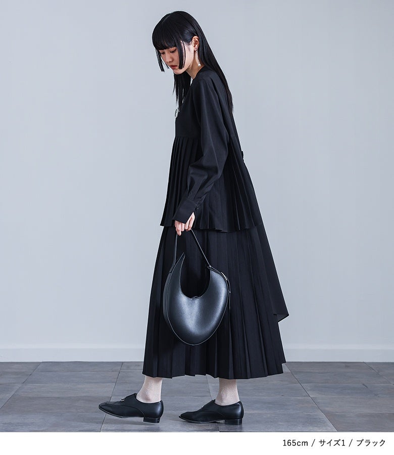 ブラックのアシンメトリープリーツワンピースに革バッグとドレスシューズを合わせた、美術館巡りや観劇にもおすすめのモードシックな大人の黒コーデ。