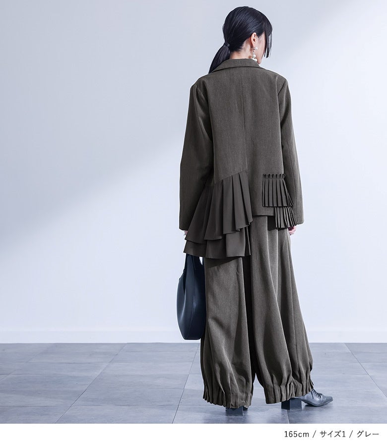 グレーの裾シャーリングタックワイドパンツ。バックスタイルまで美しい立体コクーンフォルムを保ち、オーバーサイズの羽織りと合わせてもバランス良くスマートに仕上がります。