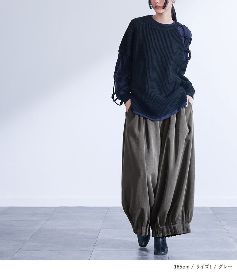 グレーの裾シャーリングタックワイドパンツにネイビーの異素材ニットをあわせた着こなし。深みのあるシックな配色とゆったりとしたバルーンラインが、大人のこなれ感を演出します。