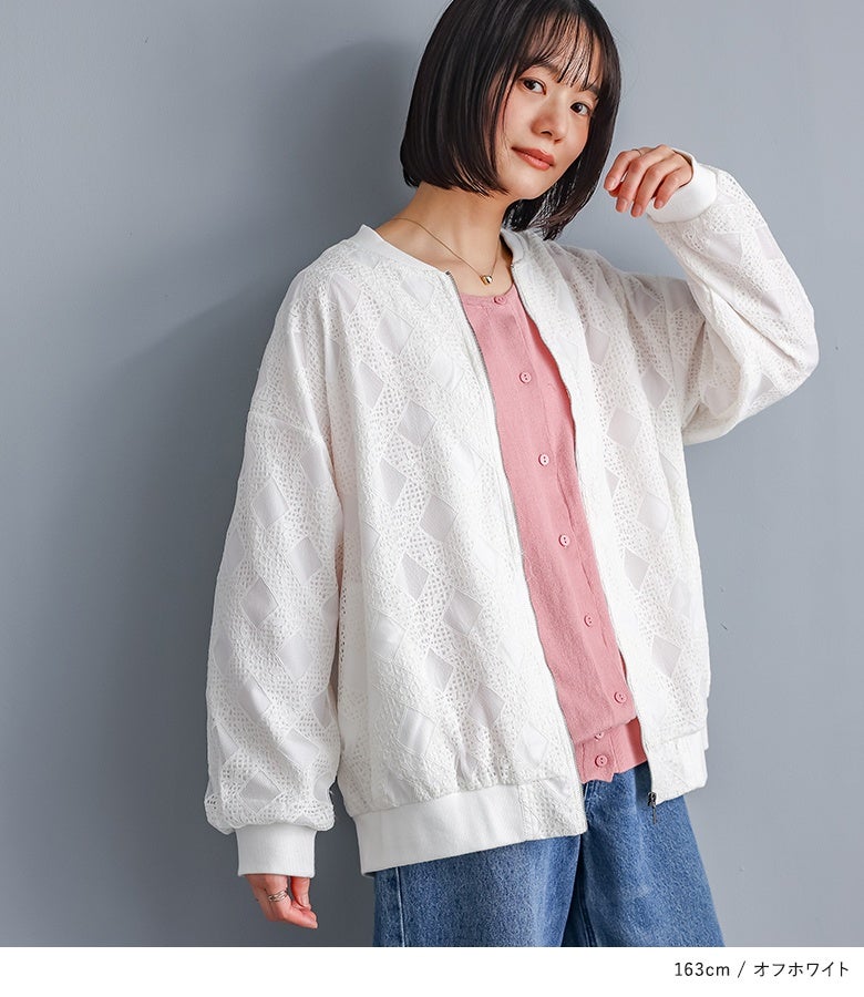 オフホワイトの幾何学柄レースブルゾンにピンクのカーディガンとデニムパンツを合わせた大人カジュアル。フロントファスナーの開き具合で、インナー魅せもおしゃれに楽しめます。