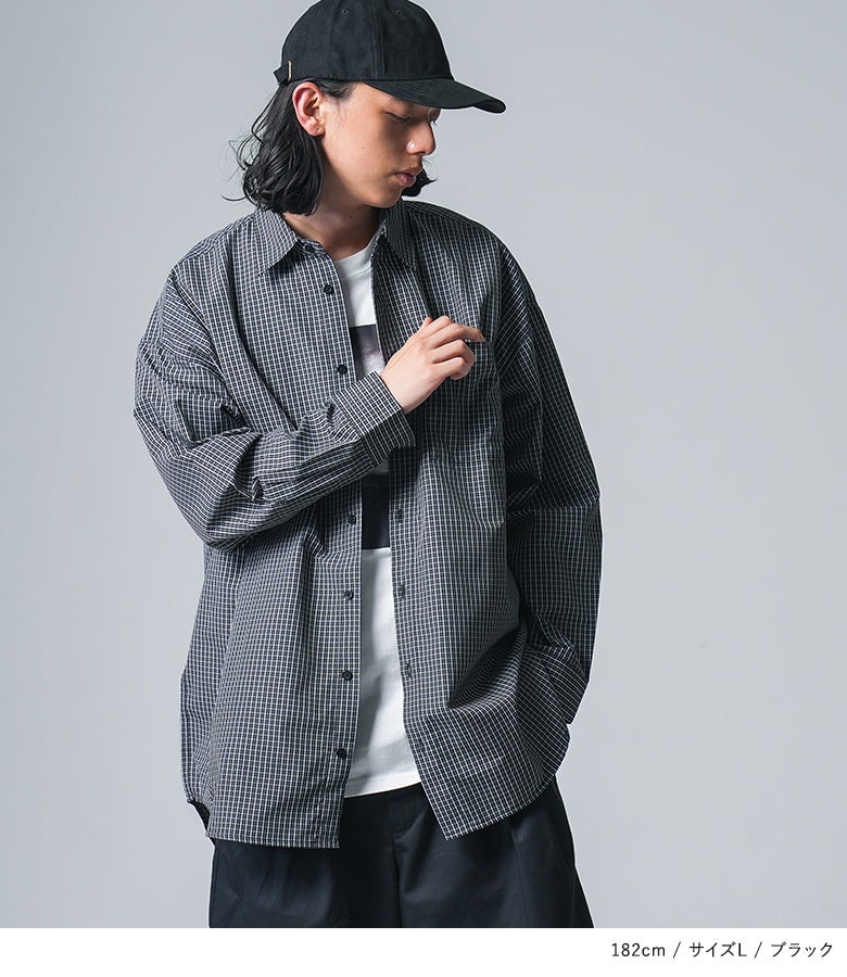 ブラックの細かなグラフチェック柄長袖シャツにプリントTシャツとキャップを合わせた、大人カジュアルな秋の休日メンズスタイル。
