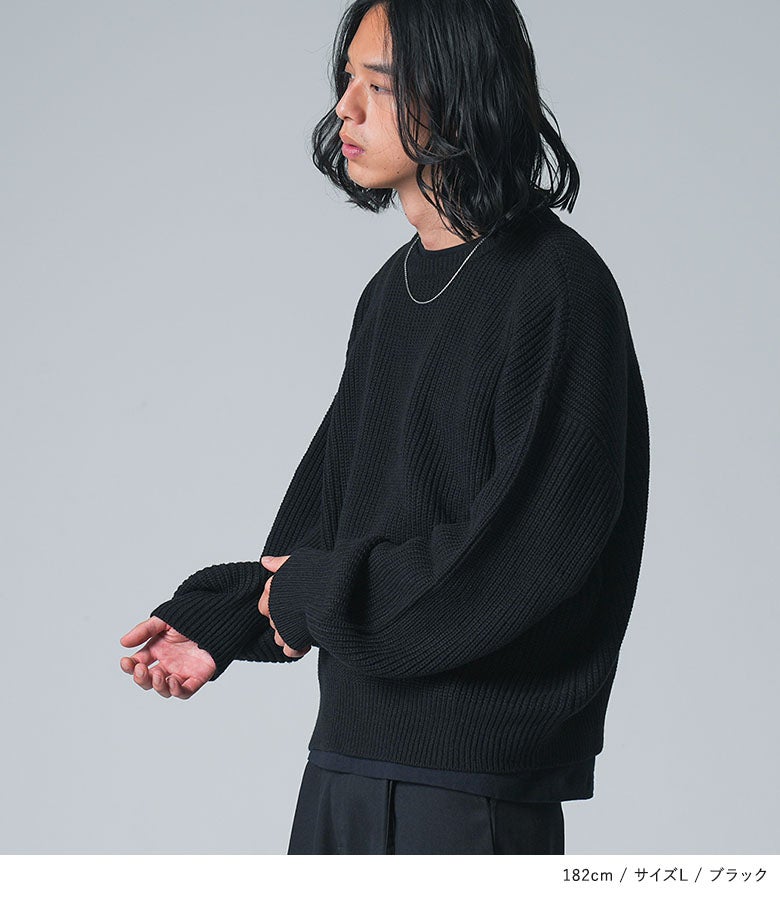 黒の畦編みショート丈ニットにシルバーネックレスを合わせた上品なメンズ秋コーデ。ゆったりとした袖のボリューム感が今年らしい印象を与えます。