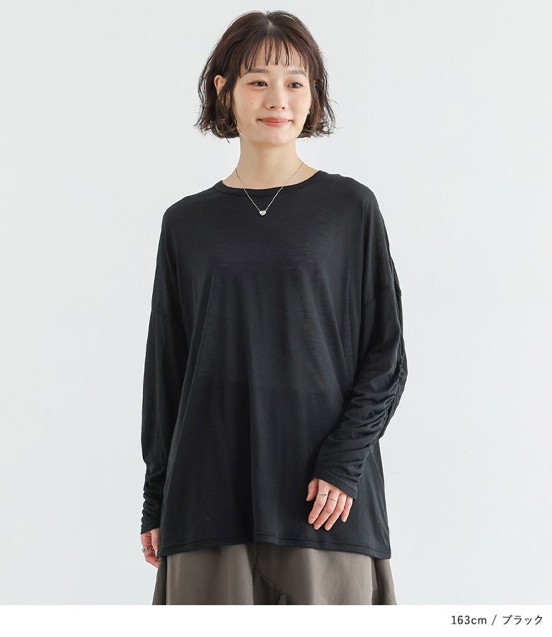 ブラックのシアー長袖トップスにカーキのパンツを合わせた、程よい透け感とシックなカラーで魅せる大人の上品ナチュラルスタイル。