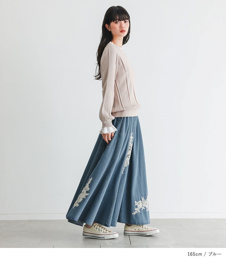 モチーフレースデニムスカートにリブニットを合わせた着こなし。足元に流れる美しいフレアラインとランダムなレース刺繍が、横姿までドラマチックに魅せてくれます。