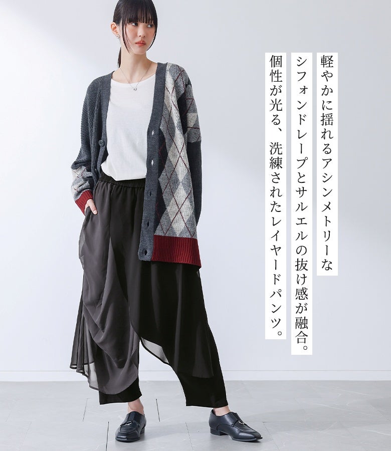 軽やかに揺れるシフォンドレープとサルエルパンツを組み合わせたアシメレイヤードパンツ。モード感漂うチャコールカラーで、柄物カーディガンやVネックニットと合わせた秋冬の洗練されたレイヤードコーデにおすすめの一着です。