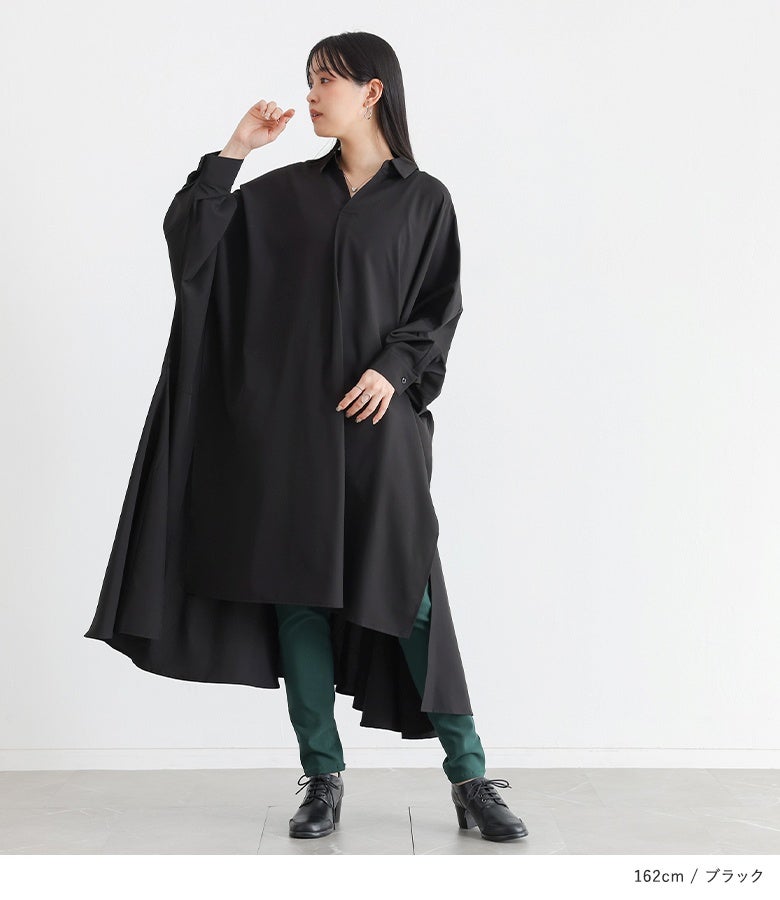 ブラックのドレープスキッパーワンピース。身幅をたっぷり取った優美なドレープシルエットと裾の変形デザインが、深みのある黒に軽やかな動きとシックな大人のモード感をプラスします。