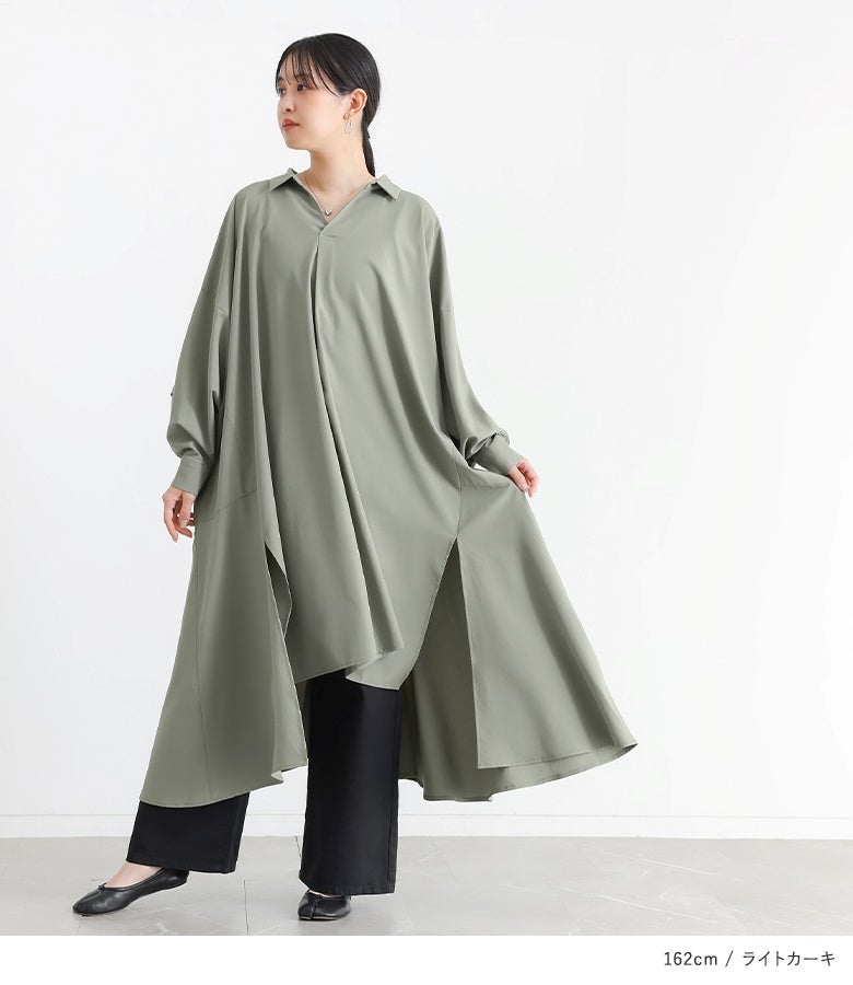 ライトカーキのドレープスキッパーワンピースに黒のワイドパンツを合わせたシックな着こなし。歩くたびに綺麗に広がる裾のフレアラインとスリットが、足元に洗練された抜け感を添えます。