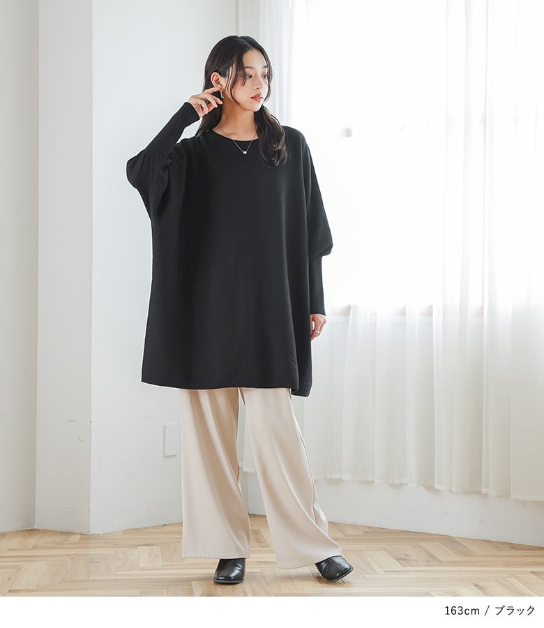 ブラックのコットン100%ドルマンチュニックニットにベージュのワイドパンツを合わせたスタイル。シックな黒のゆったりフォルムが、こなれ感と上品な落ち着きを与えます。