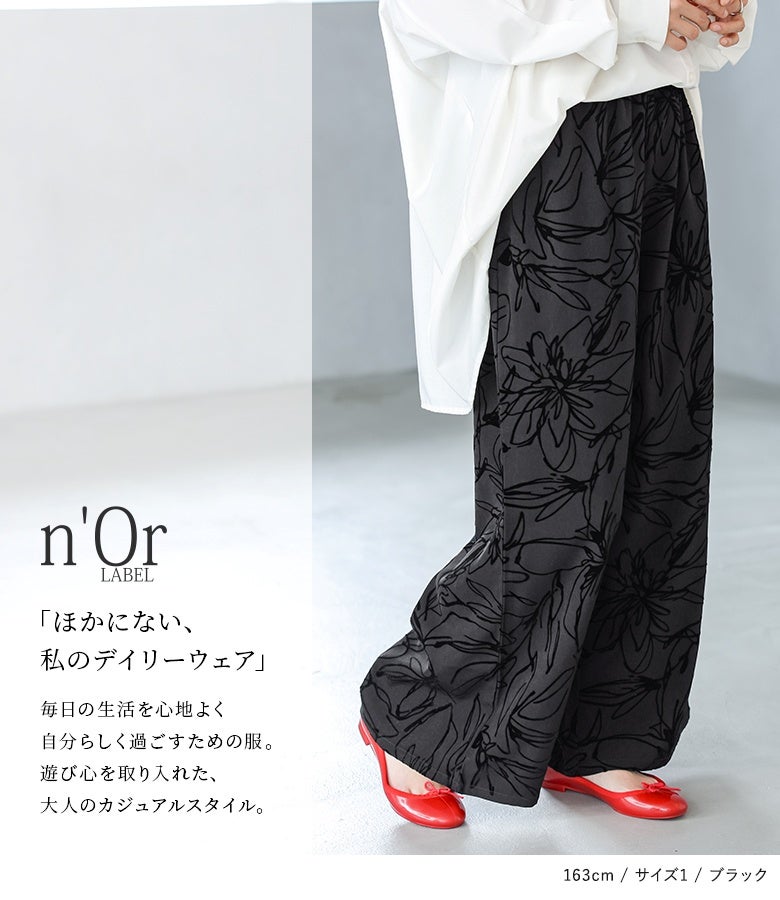 ブラックのフロッキープリントワイドパンツ。立体的な花柄デザインが光の加減でほんのり浮かび上がり、落ち感のある生地が脚のラインをまっすぐ綺麗に魅せてくれます。