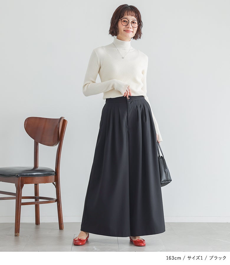 ホワイトのタートルネックニットにブラックの贅沢タックワイドパンツ、赤いバレエシューズを合わせたクラシカルな大人可愛いコーデ。