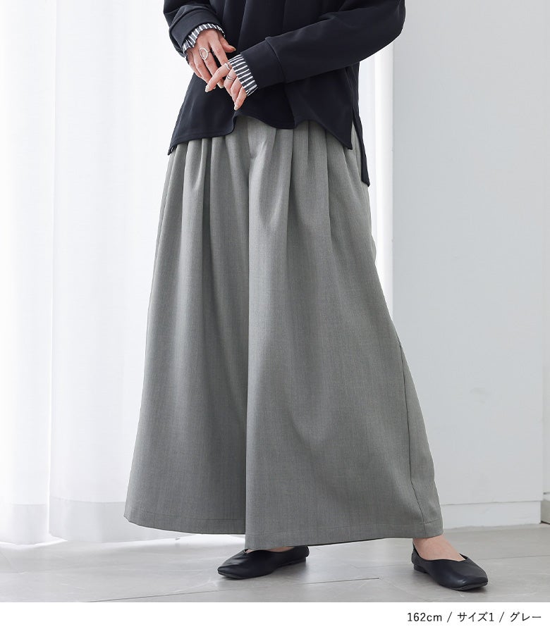 グレーの贅沢タックワイドパンツに黒のトップスを合わせた、オフィスやお出かけにぴったりの上品で大人っぽい着こなし。