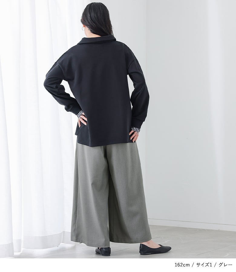 ゆったりとした黒のプルオーバーにグレーの贅沢タックワイドパンツを合わせた、リラックス感とお洒落さを両立した大人カジュアルコーデ。