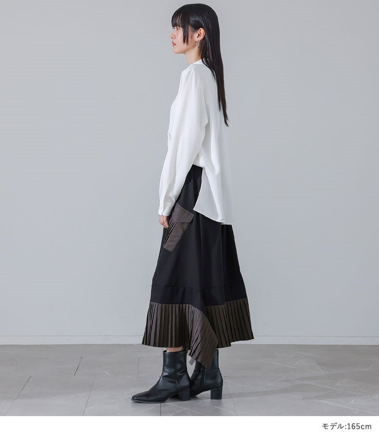 ブラックのアシメプリーツ切替スカート。サイドから流れるプリーツの綺麗な落ち感と変形ヘムラインが、横姿にもこなれた雰囲気を醸し出します。