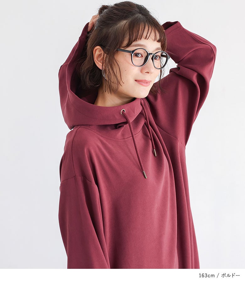 立体的な大きめフードと高めのスタンドカラーが印象的なボルドーの長袖ロングワンピース。顔まわりを華やかに見せ、寒さ対策と大人可愛いスタイルを両立します。