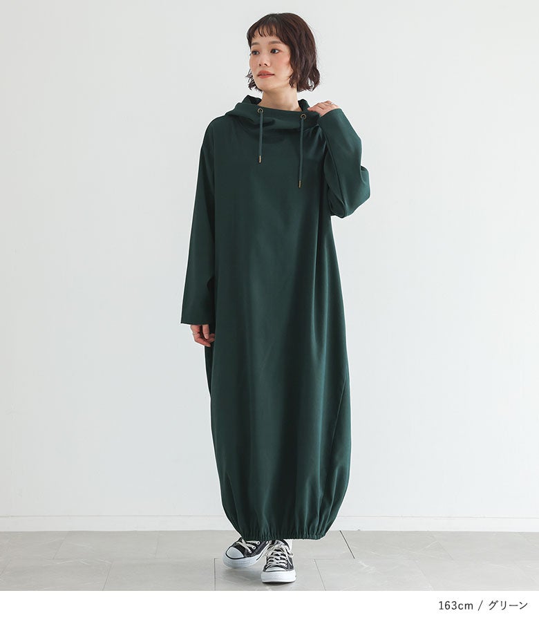 落ち着いたグリーンのフード付きバルーンロングワンピース。スタンドカラー風の首元と丸みのある裾シルエットが特徴で、リラックスした着心地ながら一枚でおしゃれに決まる、秋のリラックススタイルです。