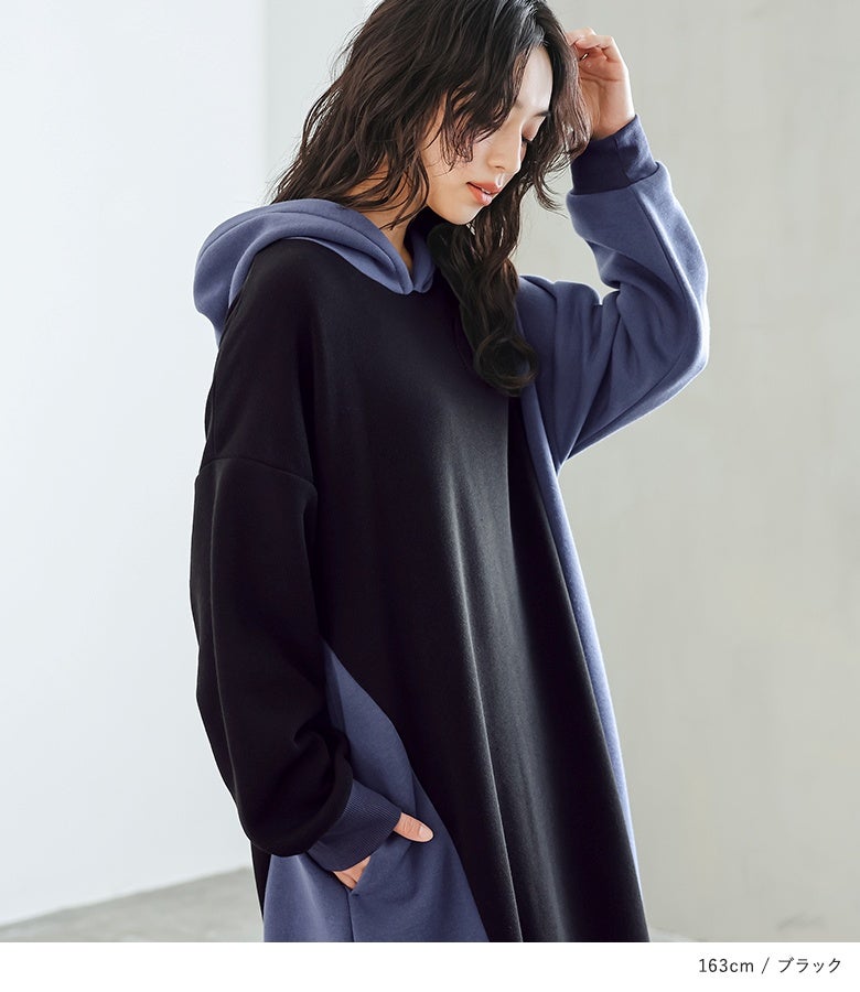 ブラック地の裏起毛アシメ配色フーディーワンピース。首元を温かく包み込むフードワークと立体的な配色スリーブが、顔周りや上半身を惹き立てます。