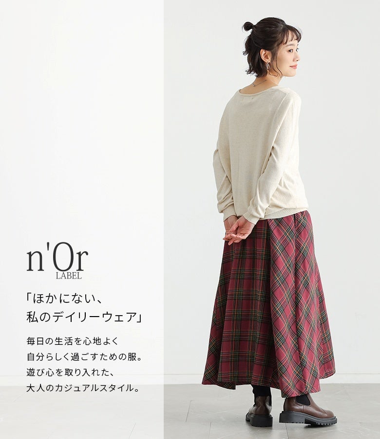 レッドの微起毛チェック柄フレアスカート。深みのある赤系チェックと落ち感のあるロングシルエットが、アイボリーのシンプルニットをあわせた装いを可憐かつ上品に魅せます。