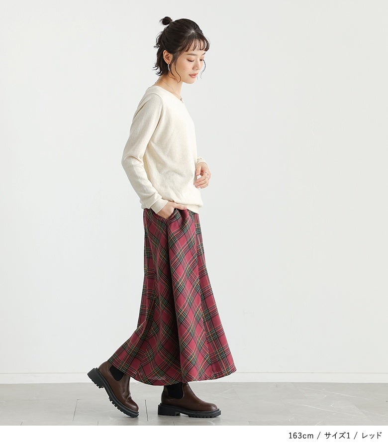レッドの微起毛チェック柄フレアスカート。深みのある赤系チェックと落ち感のあるロングフレアが、アイボリーのシンプルニットを合わせた装いを大人可愛く彩ります。