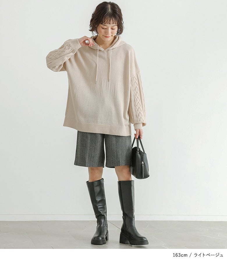 ライトベージュのニットパーカーにヘリンボーン柄ショートパンツと黒のロングブーツを合わせた、上品でアクティブな秋冬のドライブ・お出かけスタイル。