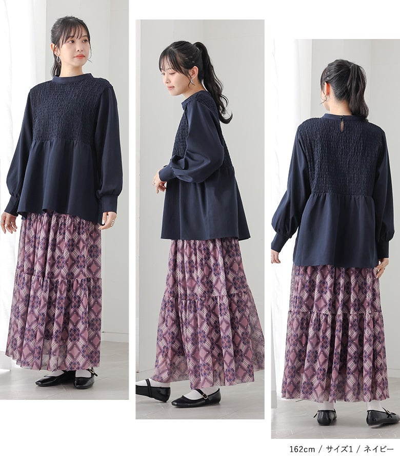 ネイビーのスモッキング刺繍デザインブラウス。胸元の繊細なギャザーとぽわん袖フォルムが、どの角度から見ても立体感のある綺麗なAラインシルエットを描きます。