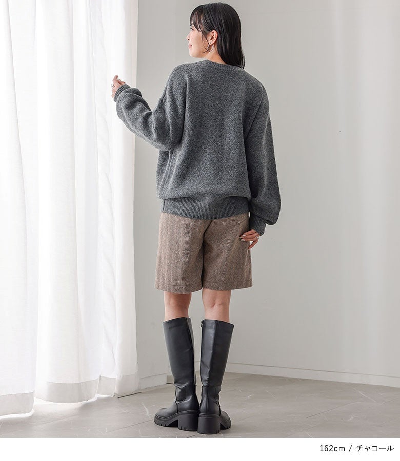 コード刺繍ロゴニットのバックスタイル。お尻にかかる程よい丈感とドロップショルダーが、後ろ姿にもリラックスした雰囲気を醸し出します。