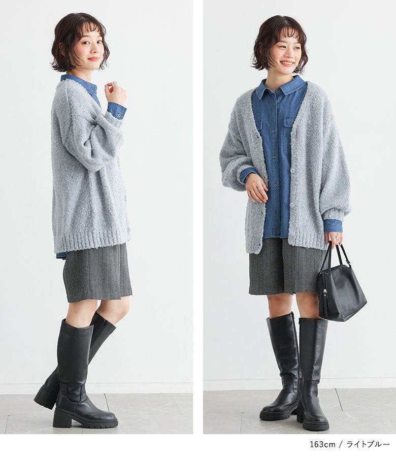 ライトブルーのブークレカーディガンとヘリンボーン柄ショートパンツ、黒ロングブーツの爽やかな大人カジュアルコーデ。シックなレザーバッグを合わせた秋のお出かけスタイル。
