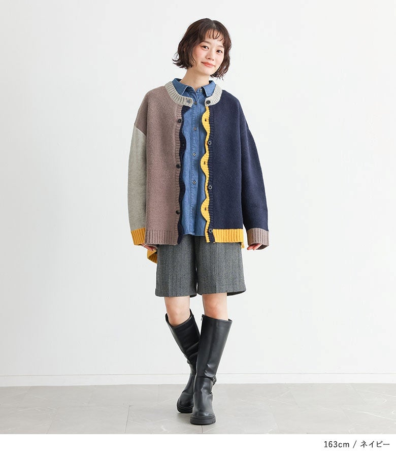 配色ニットカーディガンにデニムシャツとグレーのハーフパンツ、ロングブーツをあわせたカジュアルスタイル。フロントの波打つイエローの切り替えラインが着こなしのアクセントになっています。