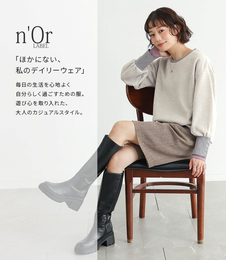 オートミールの袖配色リブスウェットにチェック柄ショートパンツと黒のロングブーツを合わせた甘辛MIXスタイル。休日のお散歩やカフェ巡りにぴったりな大人カジュアルコーデ。