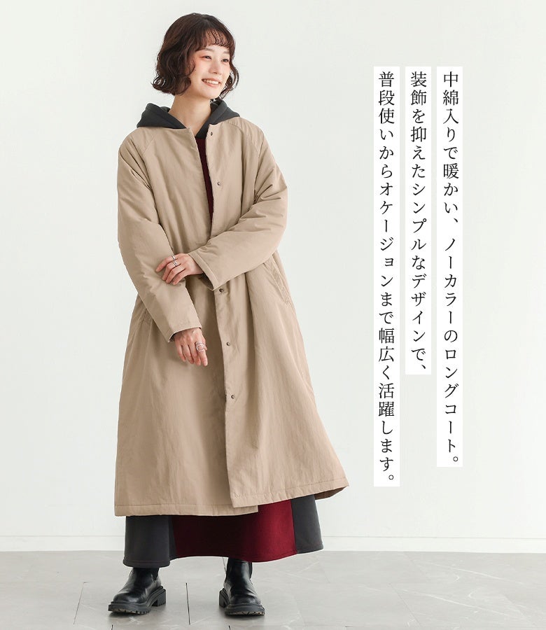 中綿入りで暖かいベージュのノーカラーロングコート。装飾を抑えたシンプルなデザインで、普段使いからオケージョンまで幅広く活躍。フード付きの切り替えワンピースとブーツを合わせた、こなれ感のある大人カジュアルスタイル。